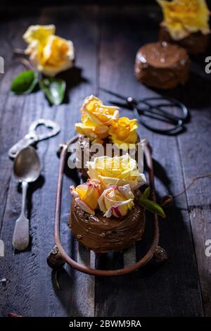 Chocolate cake on a wooden table.Sweet dessert with flowers.Vintage style.Low fat food. Stock Photo