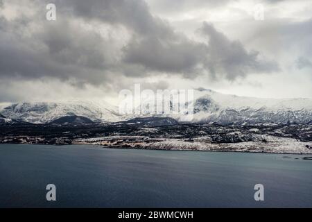 Bodo, Norway. Aerial view of Bodo, Norway in the cloudy morning. View of the famous northern fjord from above in winter with snow covered mountains. G Stock Photo