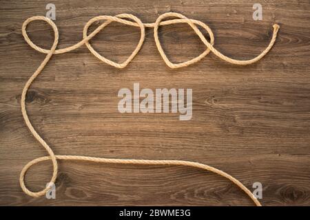Two heart shapes on an old wooden wall made from knitted rope Stock Photo