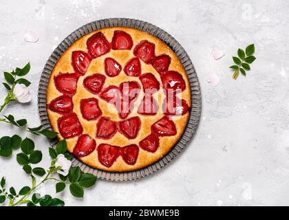 Traditional fresh baked strawberry curd cake with decorated with flowers on grey background. Delicious homemade sweet food concept. Copy space. Stock Photo