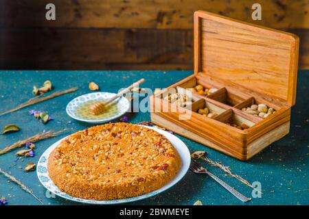 Cake on table with wooden box full of various nuts Stock Photo