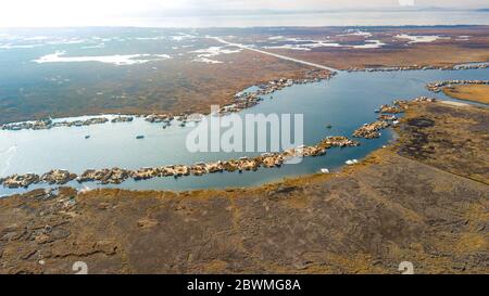 An aerial high view of Uros floating islands settlements at Lake Titicaca, Peru, islands next to each other on both opposite sides of Totora plantations. Stock Photo