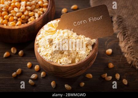 Corn flour  in a wooden bowl isilated on a wooden background Stock Photo