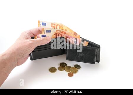 Hand of a woman with a wallet and few euro coins and banknotes, money check in poverty due to an economic crisis for example by coronavirus, isolated Stock Photo