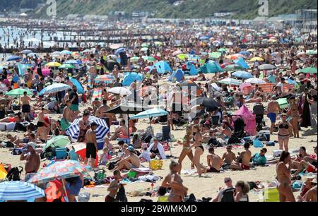 People on the beach in Bournemouth, Dorset, as the public are being reminded to practice social distancing following the relaxation of the coronavirus lockdown restrictions in England. Stock Photo