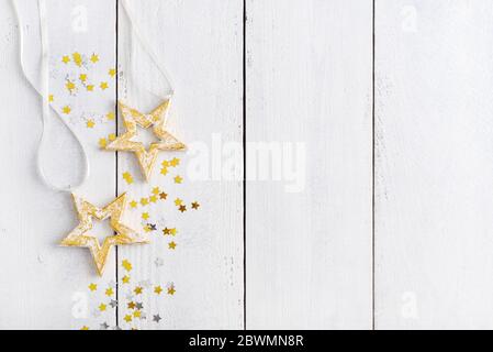 Christmas decorations in shape of stars on white wooden background, top view Stock Photo