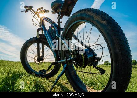 Electric bicycle with thick wheels in nature. Fatbike close-up. Stock Photo