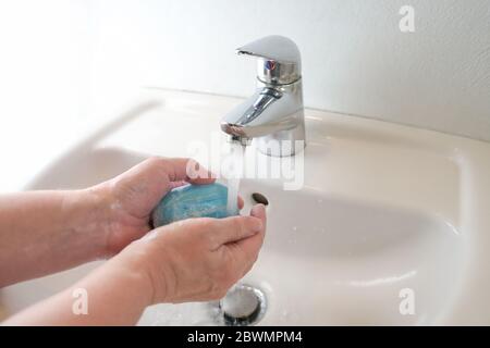 Washing hands under the faucet with water and soap reduces the risk of coronavirus infection, hygiene and healthcare concept, copy space, selected foc Stock Photo