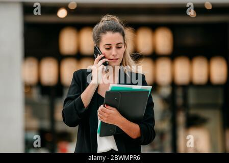 young business woman talks on the phone on the street Stock Photo