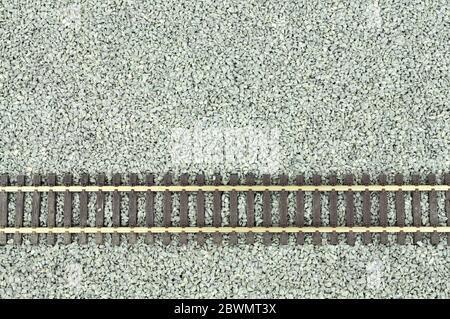 Fine grey gravel background used as track ballast for model railways with section of track Stock Photo