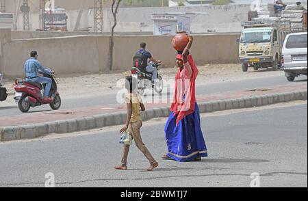 Beawar, Rajasthan, India - June 2, 2020: An rajasthani woman carry clay pot filled with drinking water to their homes in a dust storm, in Beawar. Credit: Sumit Saraswat/Alamy Live News Stock Photo