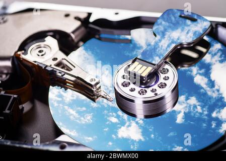 A cloudy sky is reflected on the magnetic disk of a hard disk and on a USB stick Stock Photo