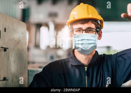 Worker wearing disposable face mask or HEPA face shield for protection from Coronavirus(Covid-19) spreading and toxic smoke dust air pollution in fact Stock Photo