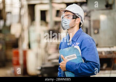 Worker wearing face shield or disposable face mask with Coronavirus(Covid-19) Prevention guidlines manual hand book for guidance rule to healthy work Stock Photo