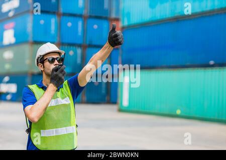 Foreman shipping staff worker working to control loading cargo port logistic for import export goods at container warehouse. Stock Photo