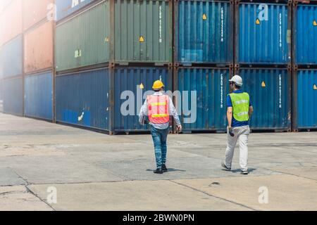 Staff worker lunch break walking security check in large cargo goods warehouse port loading containers are for shipping import export industry. Stock Photo