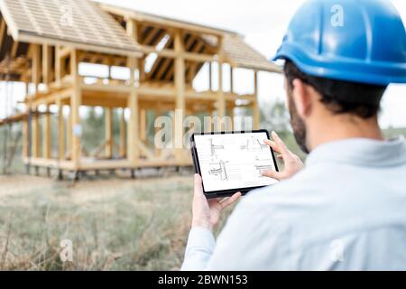 Architect or builder using digital touchpad on the construction site outdoors. Close-up on screen with copy space Stock Photo