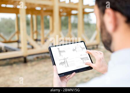 Architect or builder using digital touchpad on the construction site outdoors. Close-up on screen with copy space Stock Photo