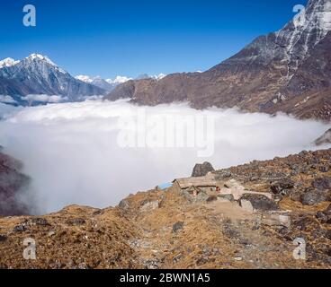 Nepal. Trek to Mera Peak. At Paiya camp leading to the Arun and Hinka valleys, looking across the cloud filled valley of the Dudh Kosi towards the sacred mountain of Kumbila in the distance Stock Photo