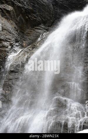 Beautiful waterfall falling hard on black rocks. Stock Photo