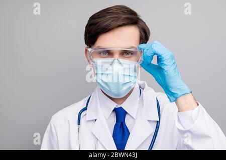 Closeup photo of attractive handsome serious doc guy professional surgeon specialist wear facial protective mask medical uniform lab coat stethoscope Stock Photo