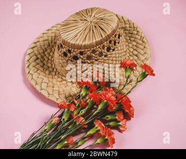 straw hat with spring flowers on pink bakcground Stock Photo