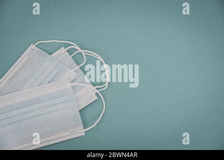 Tipical surgical masks with rubber ear straps on blue background, top view . Protection concept. Stock Photo