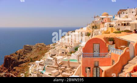 A view of Oia, a beautiful town on the greek island of Santorini, with the iconic colourful buildings built on the caldera rim of an ancient volcano. Stock Photo