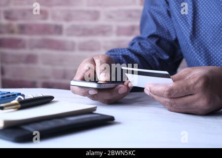 Businessman hand holding credit card and using smart phone shopping online  Stock Photo