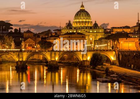 Sunset Tiber River - Colorful dusk view of Tiber river at Sant' Angelo Bridge, with St. Peter's Basilica towering in background, Rome, Italy. Stock Photo