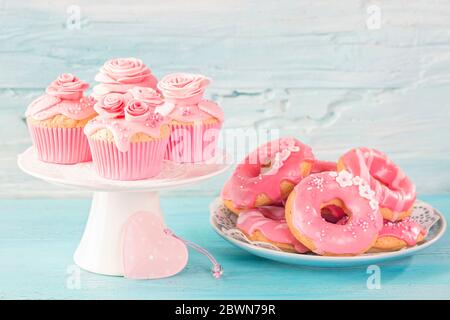 Pink donuts and cup cakes on a blue background Stock Photo