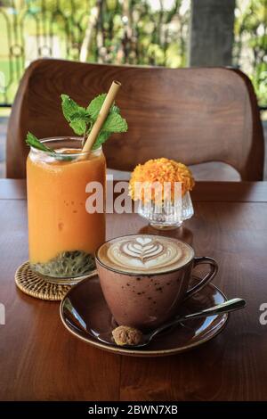 A cup of coffee with latte art on top on wooden table Stock Photo
