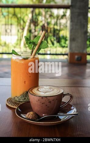 A cup of coffee with latte art on top on wooden table Stock Photo