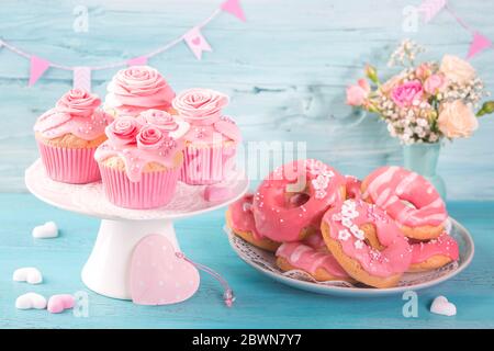 Pink donuts and cup cakes on a blue background Stock Photo