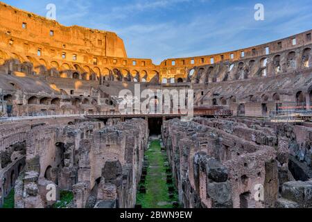 Interior of The Colosseum - A sunset view of the arena and hypogeum surrounded by ancient high walls inside of the Colosseum. Rome, Italy. Stock Photo