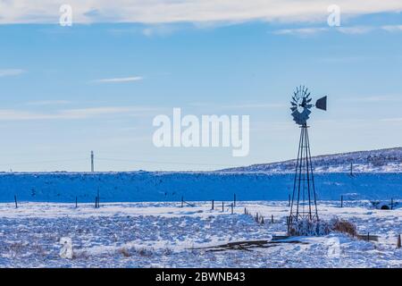 Windmill pumping water from the Ogallala Aquifer for cattle on the range in the sandhills of Nebraska, USA Stock Photo