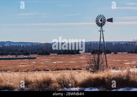 Windmill pumping water from the Ogallala Aquifer for cattle on the range in the sandhills of Nebraska, USA Stock Photo