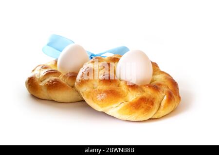 Traditional Easter bread made of sweet yeast dough in the shape of a nest with a boiled egg, isolated on a white background, selected focus, narrow de Stock Photo