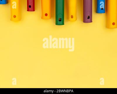 Colored handles for paint roller on a yellow background. Stock Photo