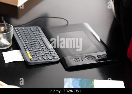 Simple modern clean office desk workspace area with a keyboard and a graphics tablet, nobody. Computer artist, graphic designer simplified work space Stock Photo