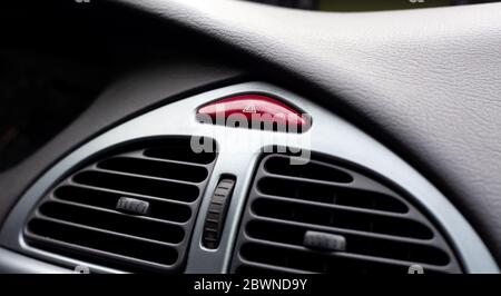 Simple red hazard warning lights button on car dashboard, triangle pictogram closeup, detail shot. Vehicle safety light alert signal, transportation Stock Photo