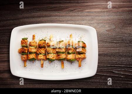 Directly above shot of Teriyaki glazed salmon skewers with green peppers served in a plate Stock Photo