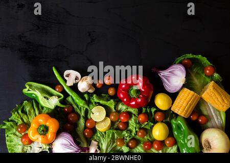 Various fresh vegetables arranged on black surface Stock Photo