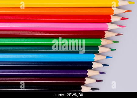 colored wooden pencils of different colors arranged on a light background Stock Photo