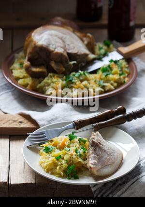 Baked pork knuckle served with stewed cabbage and beer. Rustic style. Stock Photo