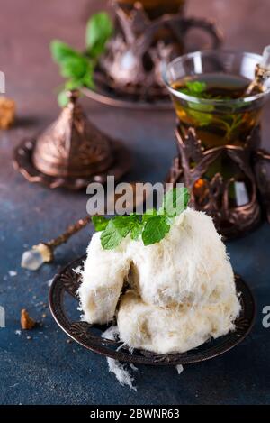 Traditional Turkish cotton candy called Pismaniye in vintage plate with tea on stone Stock Photo