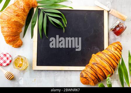 Chalk board with croissant, jam, berries and cup flat lay mock-up,