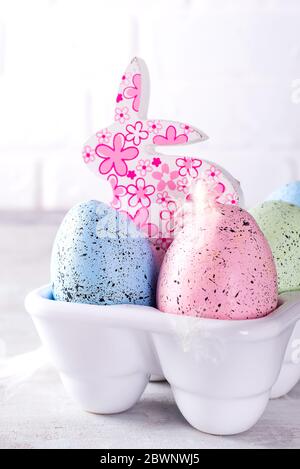 Organic colorful easter eggs with cutie bunny in porcelain decorative box on white. Holiday Easter concept . Stock Photo