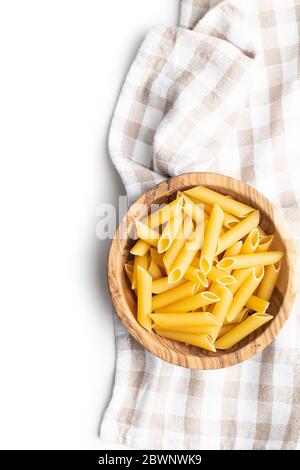 Uncooked penne pasta. Dried italian pasta in wooden bowl isolated on white background. Stock Photo