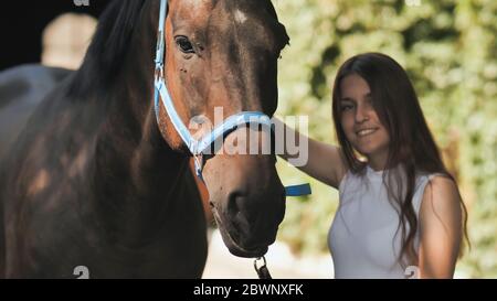 Happy girl with her beloved horse on a summer day. Stock Photo